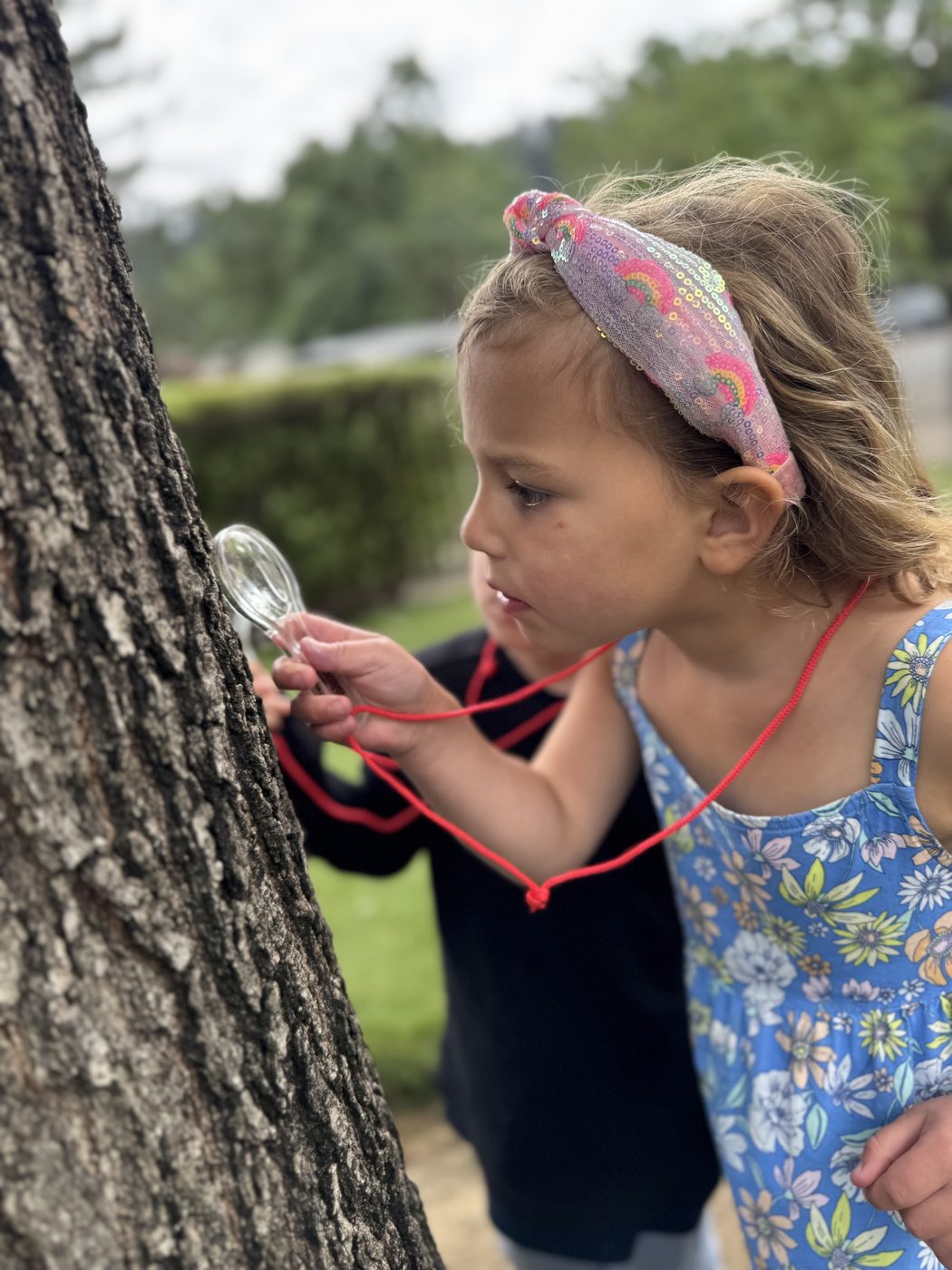 Girl exploring nature with magnifying glass at TRP summer camp
